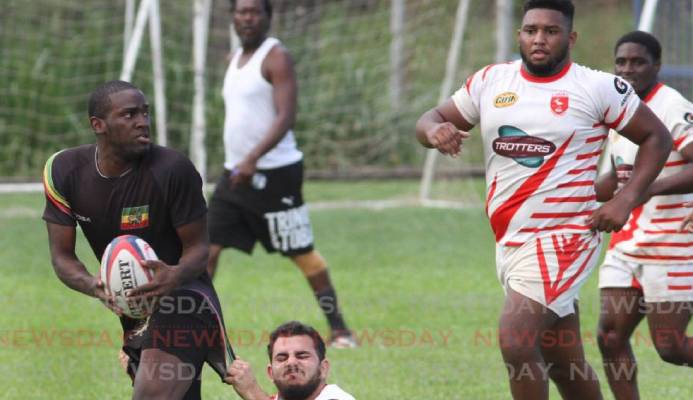 A Carib RC player, tackles a Rainbow RC player, in the Rugby International Sevens Tournament, at St. Mary's Grounds, St. Clair on Sunday. PHOTO:ANGELO M. MARCELLE - A Carib RC player, tackles a Rainbow RC player, in the Rugby International Sevens Tournament, at St. Mary's Grounds, St. Clair on Sunday. PHOTO:ANGELO M. MARCELLE -