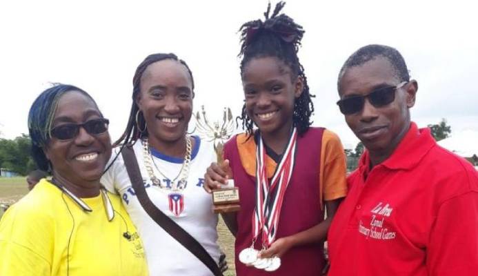 La Brea RC athlete, Chelcia Joseph (second from right), shows off her Girls U-11 Victrix trohpy and four gold medals (long jump, 100m, 200 and 4x100m relay) at her zone's Primary Schools' Track and Field Championships at Sobo Recreation Ground on February 14. She is joined by (left to right) La Brea RC teacher Sharnol Smith-Small, mother Mitchelle Joseph and principal Leon Charles. - Chequana Wheeler La Brea RC athlete, Chelcia Joseph (second from right), shows off her Girls U-11 Victrix trohpy and four gold medals (long jump, 100m, 200 and 4x100m relay) at her zone's Primary Schools' Track and Field Championships at Sobo Recreation Ground on February 14. She is joined by (left to right) La Brea RC teacher Sharnol Smith-Small, mother Mitchelle Joseph and principal Leon Charles. - Chequana Wheeler