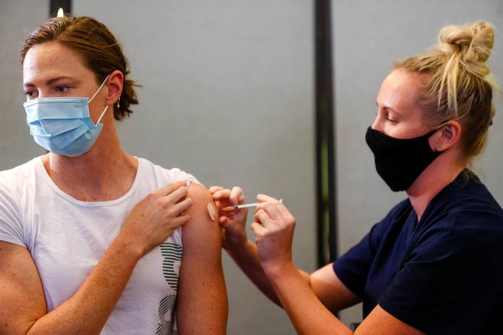 Three time Olympian, Australian swimmer Cate Campbell (left), receives her dose of Pfizer/BioNTech vaccine against covid19 at the Queensland Sports and Athletics Centre in Brisbane on May 10, after the Australian Olympic Committee began their rollout of vaccinations for members of the Olympic team ahead of the Games in Tokyo. (AFP PHOTO) - Three time Olympian, Australian swimmer Cate Campbell (left), receives her dose of Pfizer/BioNTech vaccine against covid19 at the Queensland Sports and Athletics Centre in Brisbane on May 10, after the Australian Olympic Committee began their rollout of vaccinations for members of the Olympic team ahead of the Games in Tokyo. (AFP PHOTO) -