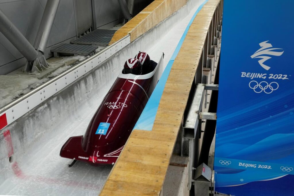 FINE-TUNING: Axel Brown and Andre Marcano of Trinidad and Tobago speed down the track during a two-man bobsleigh training run Saturday, at the 2022 Winter Olympics, in the Yanqing district of Beijing, China. —Photo: AP FINE-TUNING: Axel Brown and Andre Marcano of Trinidad and Tobago speed down the track during a two-man bobsleigh training run Saturday, at the 2022 Winter Olympics, in the Yanqing district of Beijing, China. —Photo: AP