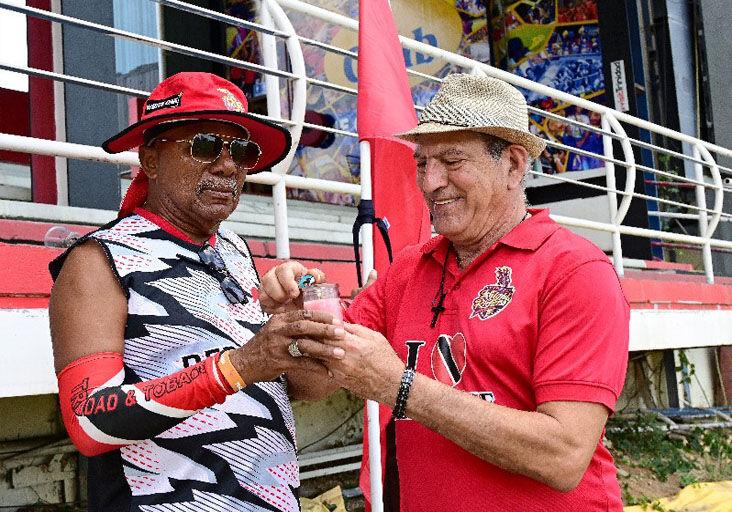 HONOURING JUMBO: Sports super fans Joey “Porche” Richardson, left, and Sam Salloum of the Trini Posse Stand light a candle yesterday to remember fellow sports fan Keith Martin, better known as “Jumbo, the nutsman”, at the Queen’s Park Oval, Port of Spain, during the second day of the West Indies Championship fifth-round match.  —Photo: JERMAINE CRUICKSHANK (Image obtained at trinidadexpress.com) HONOURING JUMBO: Sports super fans Joey “Porche” Richardson, left, and Sam Salloum of the Trini Posse Stand light a candle yesterday to remember fellow sports fan Keith Martin, better known as “Jumbo, the nutsman”, at the Queen’s Park Oval, Port of Spain, during the second day of the West Indies Championship fifth-round match.  —Photo: JERMAINE CRUICKSHANK (Image obtained at trinidadexpress.com)