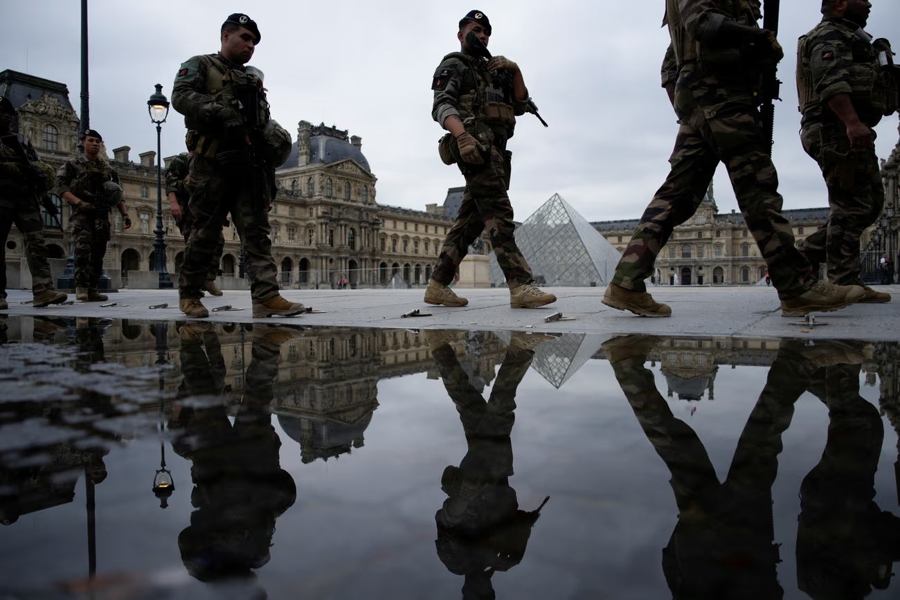 A security patrol in front of the Louvre before the opening ceremony. Fears of major disruption have been unfounded. Photograph: John Locher/Reuters (Image obtainaed at theguardian.com) A security patrol in front of the Louvre before the opening ceremony. Fears of major disruption have been unfounded. Photograph: John Locher/Reuters (Image obtainaed at theguardian.com)