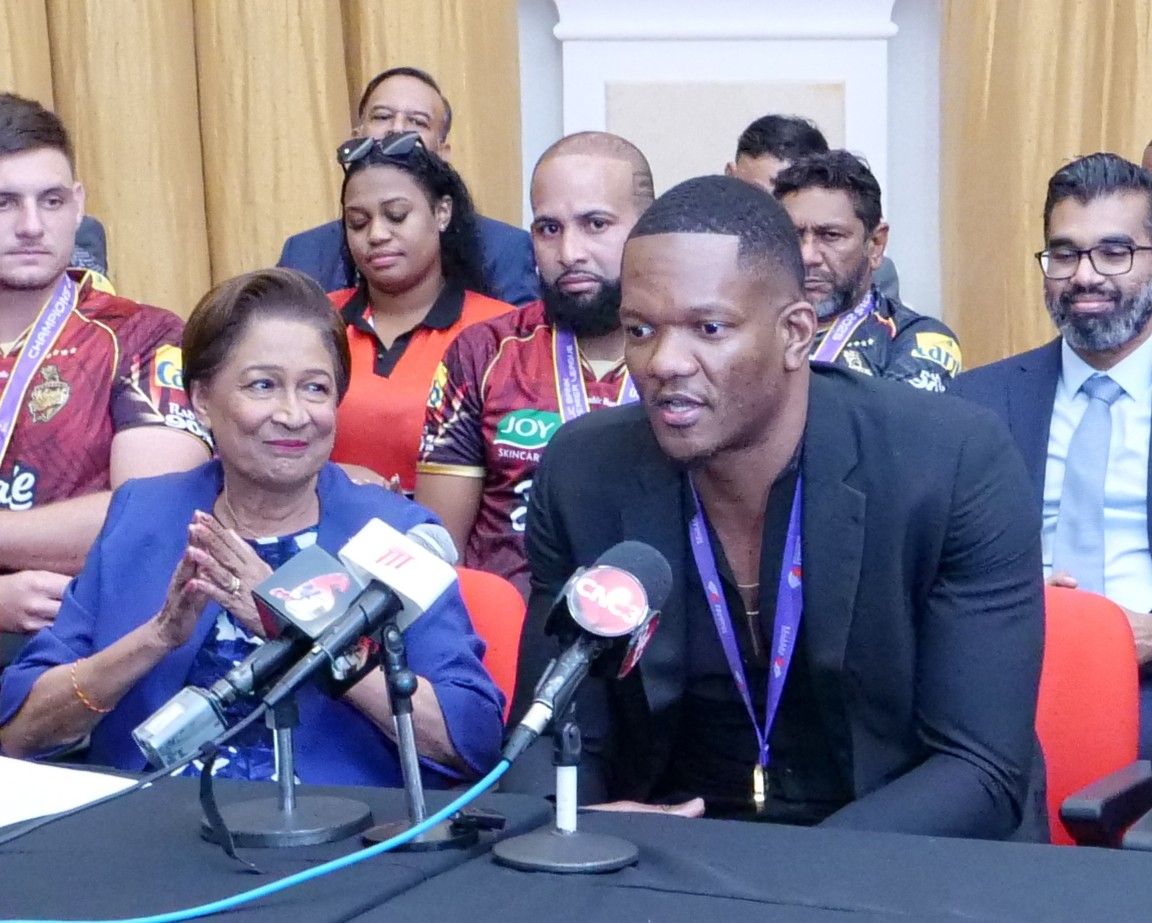 Prime Minister Kamla Persad-Bissessar listens to gold medallist Keshorn Walcott deliver remarks during a press conference at the Diplomatic Centre in St Ann's, Port-of-Spain, yesterday.  ROGER JACOB (Image obtained at guardian.co.tt)